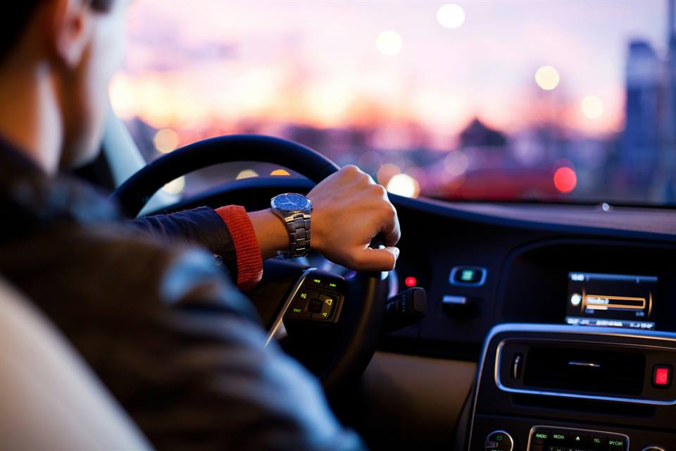 Chauffeur opening a luxury sedan in Baku at night